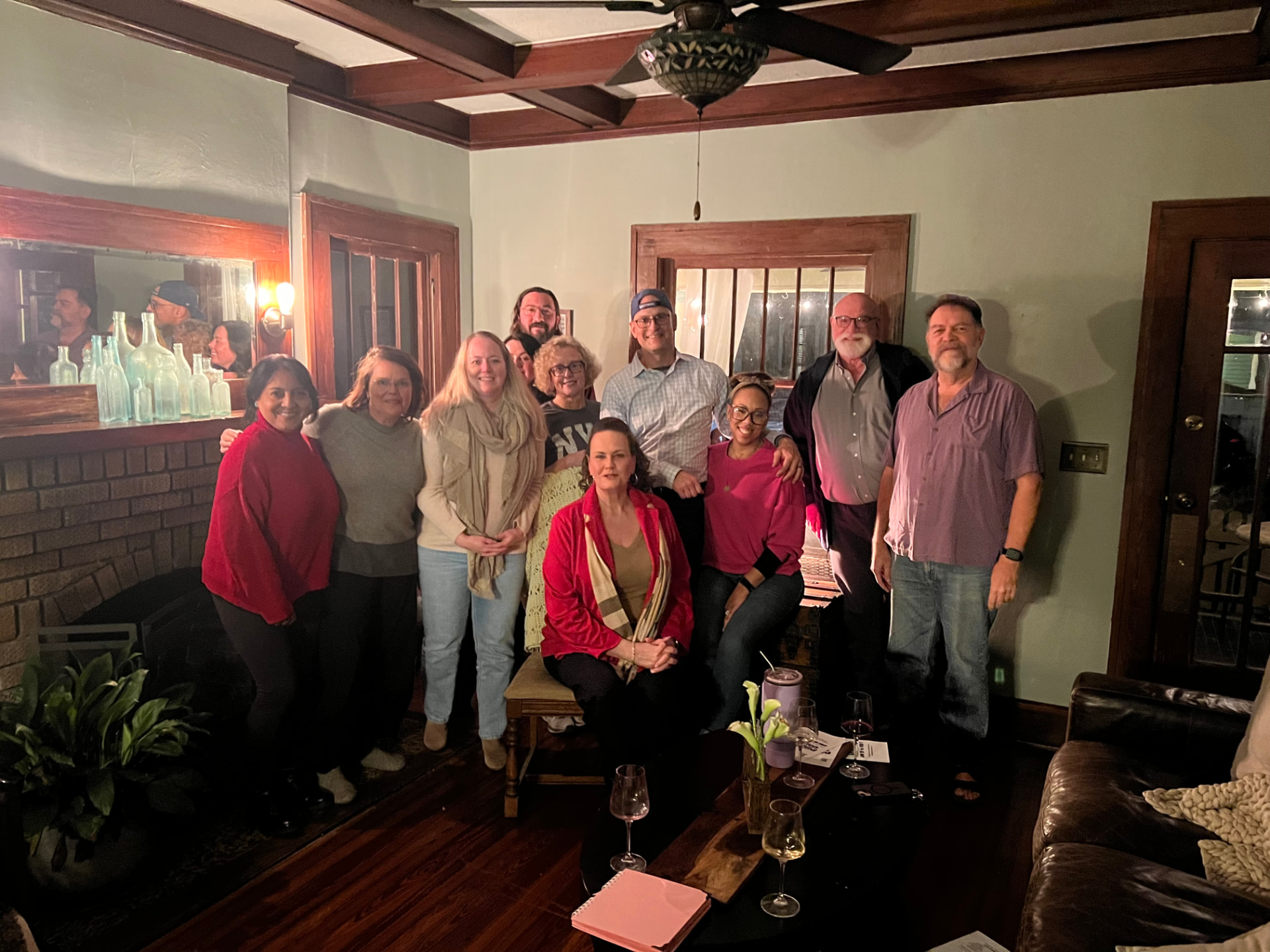 Company and community members gathered in a living room after a reading